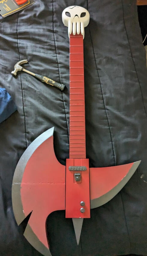 The axe guitar was 3D printed, primed, sanded, and painted. It ended up breaking at the neck in the car on the way to the con, but luckily my group and I found someone with some super glue.
